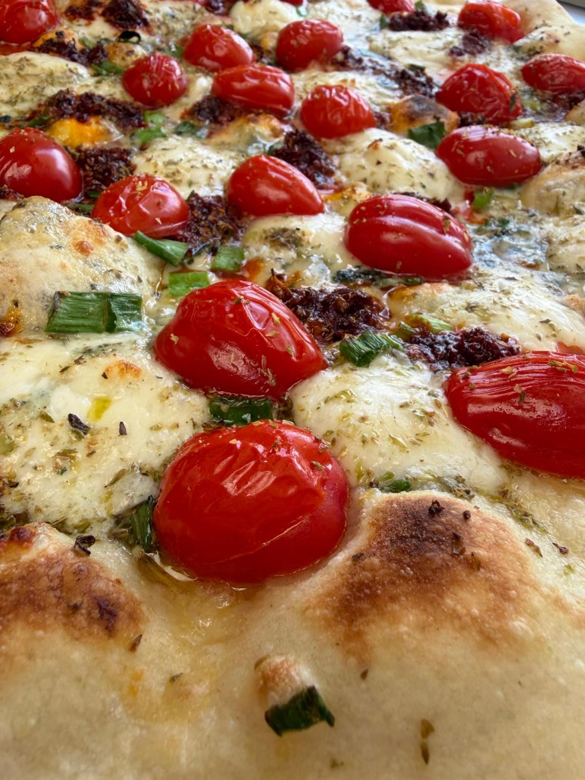 Zbliżenie na pieczone pomidorki koktajlowe na pizzy