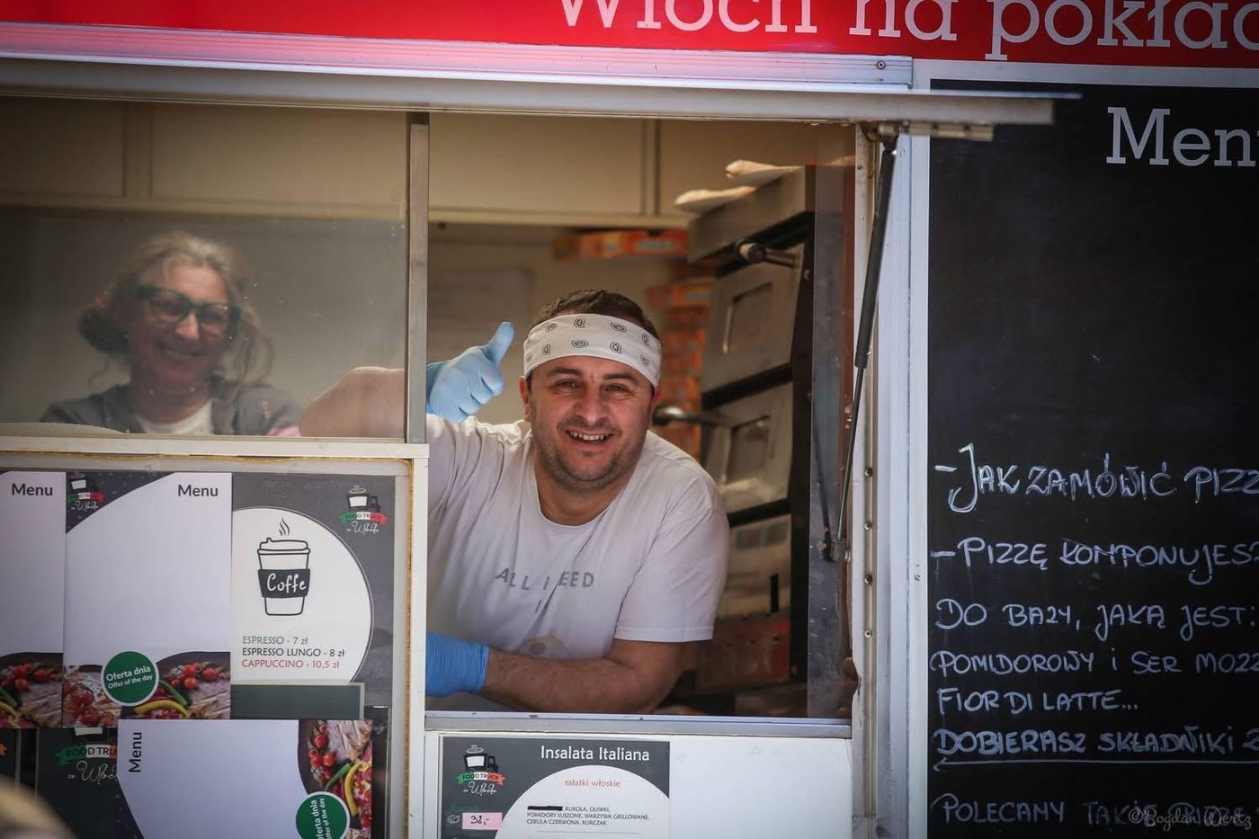 Szef kuchni pozdrawia z okna food trucka